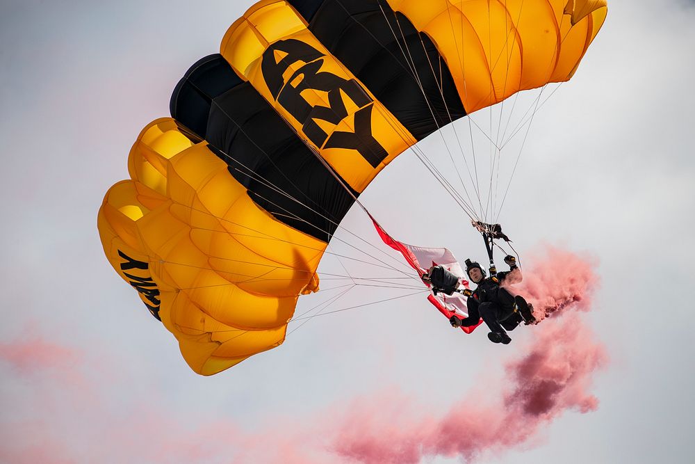 A U.S. Army Soldier with the Golden Knights Parachute Demonstration Team comes in for a landing on the beach during the…