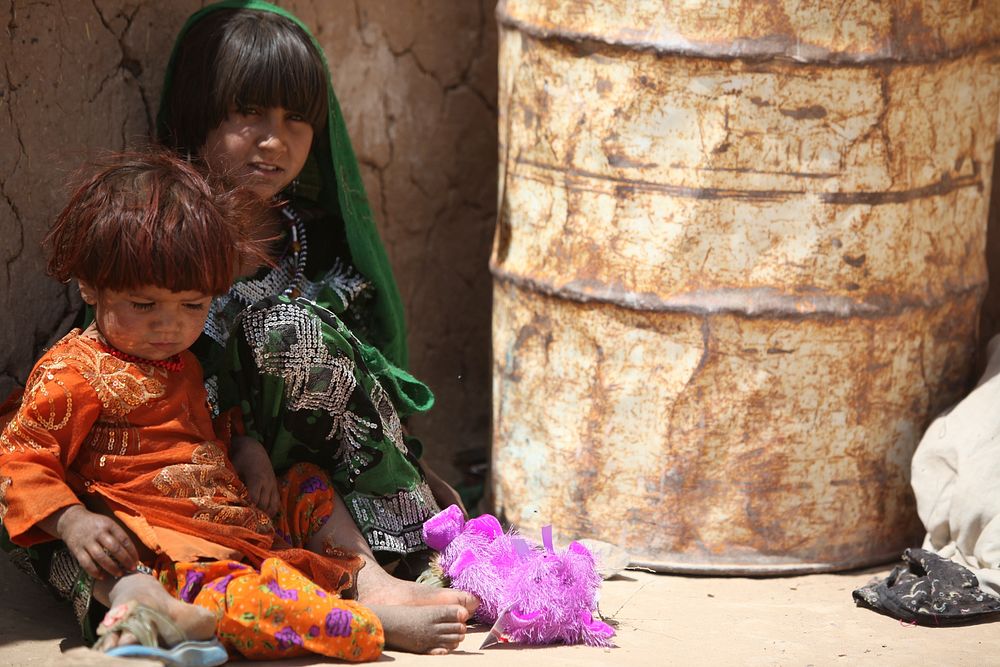 Afghan child sits with her little sister