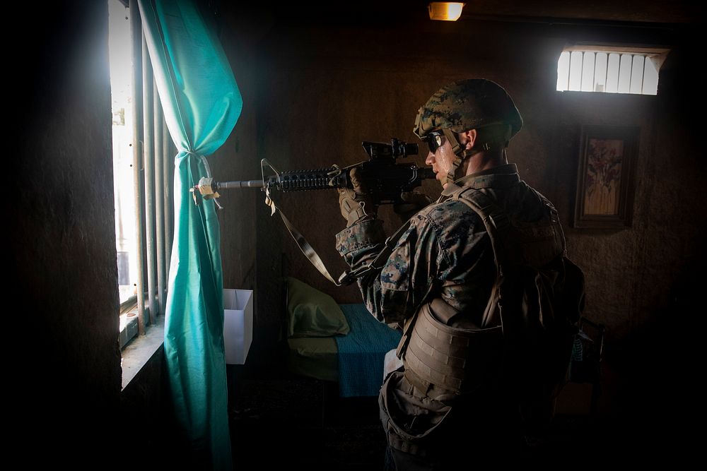 A U.S. Marine with Golf Company, 2nd Battalion, 3rd Marine Regiment, provides security from a window during a military…