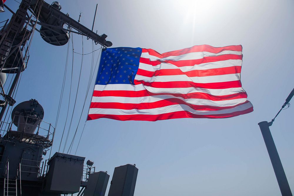 MEDITERRANEAN SEA. The national ensign flies from the mast aboard the Ticonderoga-class guided-missile cruiser USS Leyte…