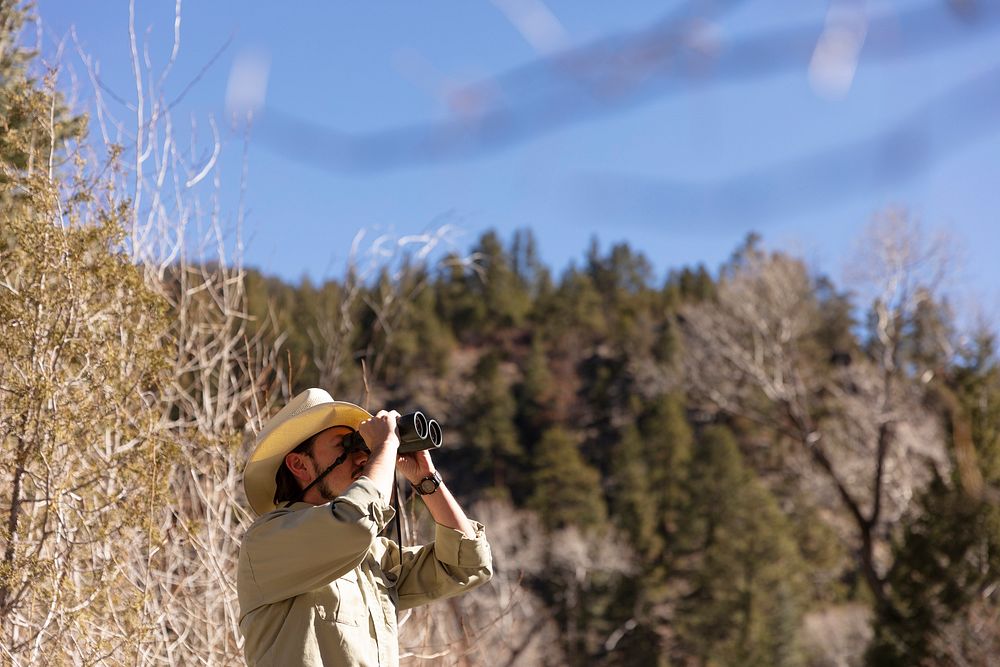 Biologist observing nature with a pair of binoculars by the Pecos River in Pecos, NM. Original public domain image from…