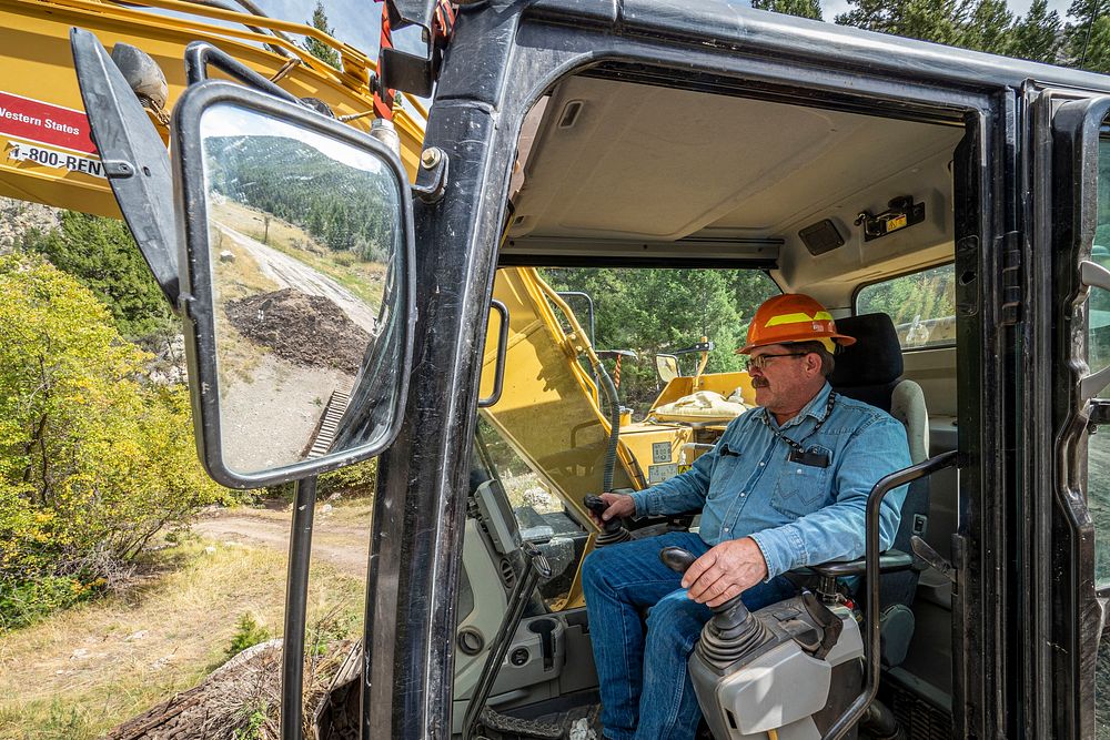 U.S. Forest Service Road Crew Supervisor J.S. Turner excavates a closed bridge to create a crossing for locals near the…