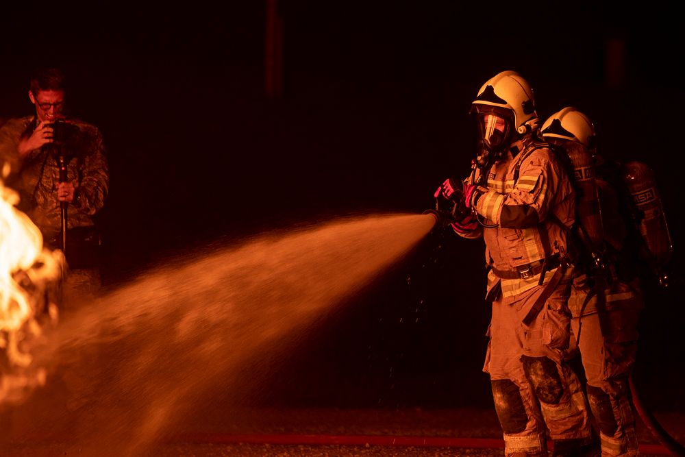 Firemen extinguishing fire. Original public domain image from Flickr