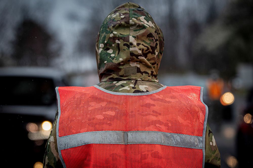 A New Jersey National Guard Airman directs traffic at a COVID-19 Community-Based Testing Site at the PNC Bank Arts Center in…