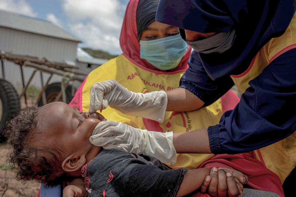 A health worker administers immunization drops to a child on 1 September 2020, during a campaign organized in Mogadishu and…