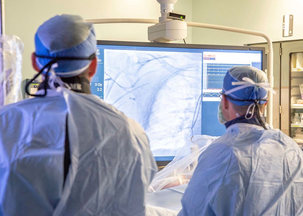 Cardiologists assigned to Naval Medical Center San Diego (NMCSD) perform a catheterization procedure using a C-arm X-ray…