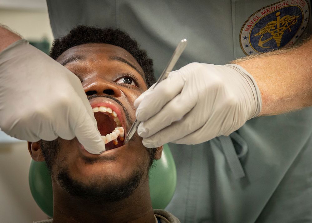 Patient&rsquo;s prosthetic denture and oral cavity are inspected in Naval Medical Center San Diego&rsquo;s (NMCSD) Dental…