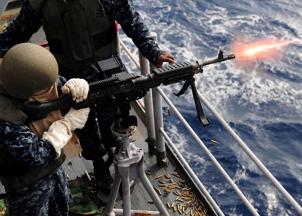 U.S. Navy Aviation Ordnanceman Airman Nicole M. Calvery fires an M-240B machine gun during a live-fire exercise aboard the…