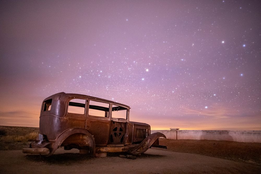Wrecked car under starry sky. Original public domain image from Flickr