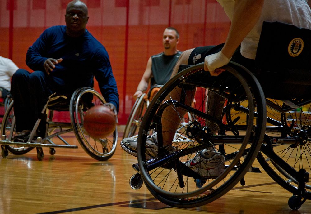 Willie Jackson, left, the coach of the San Antonio Para Sport Spurs team, dribbles the ball up court during a scrimmage game…