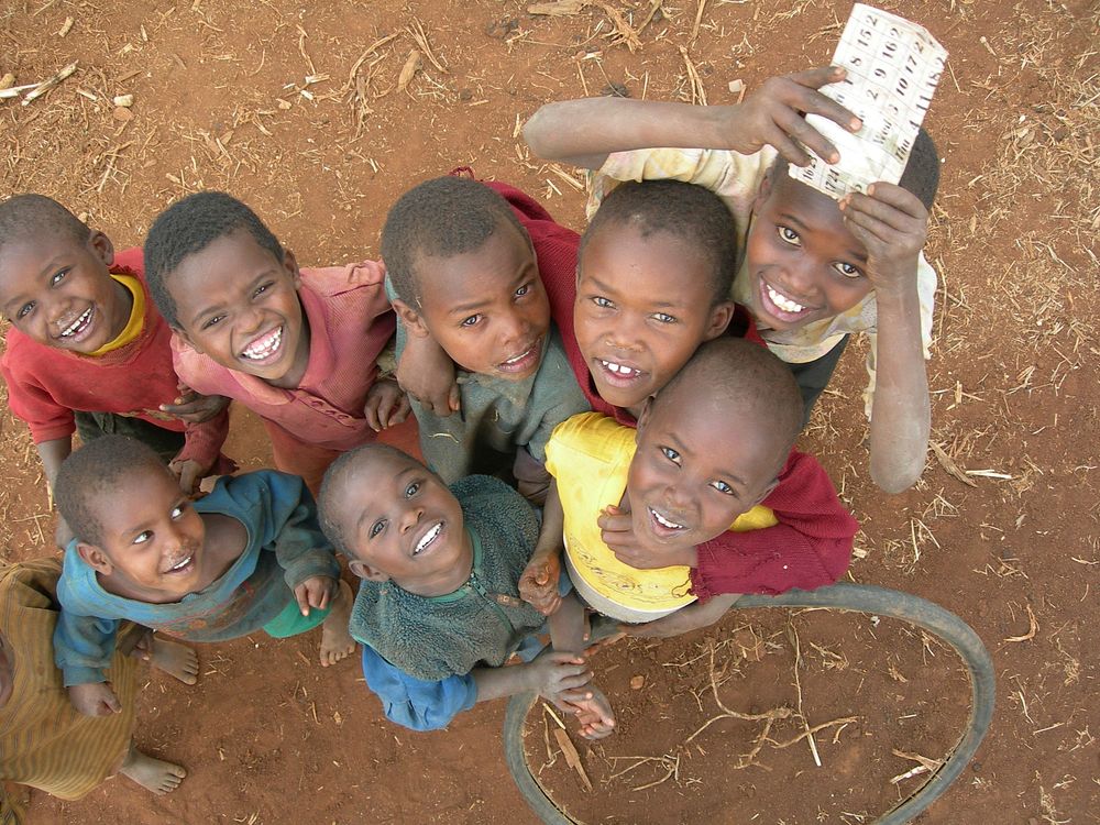 Young boys grouped together, looking at the Volunteer taking the photo. Original public domain image from Flickr