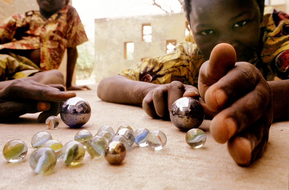 Two children play marbles in Ghana. Original public domain image from Flickr