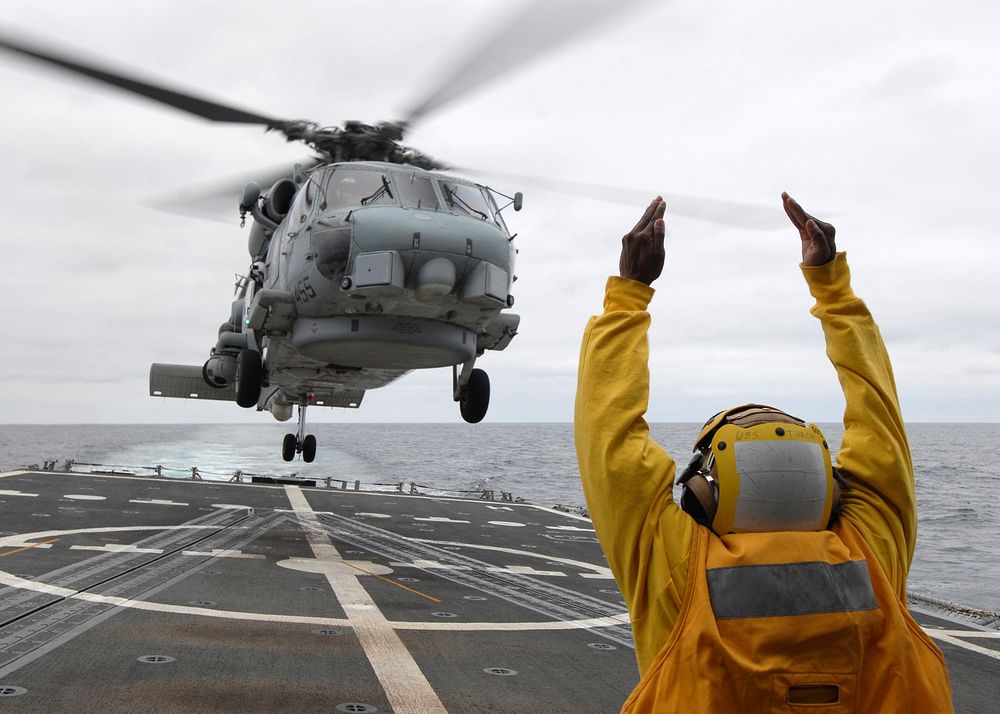 110711-N-ZI300-135 PACIFIC OCEAN (July 11, 2011) A landing signal enlisted (LSE) signals to the pilots of an SH-60B Sea Hawk…