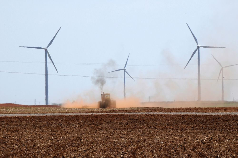 A tractor tills the soil among wind turbines in Oklahoma on August 13, 2009.
