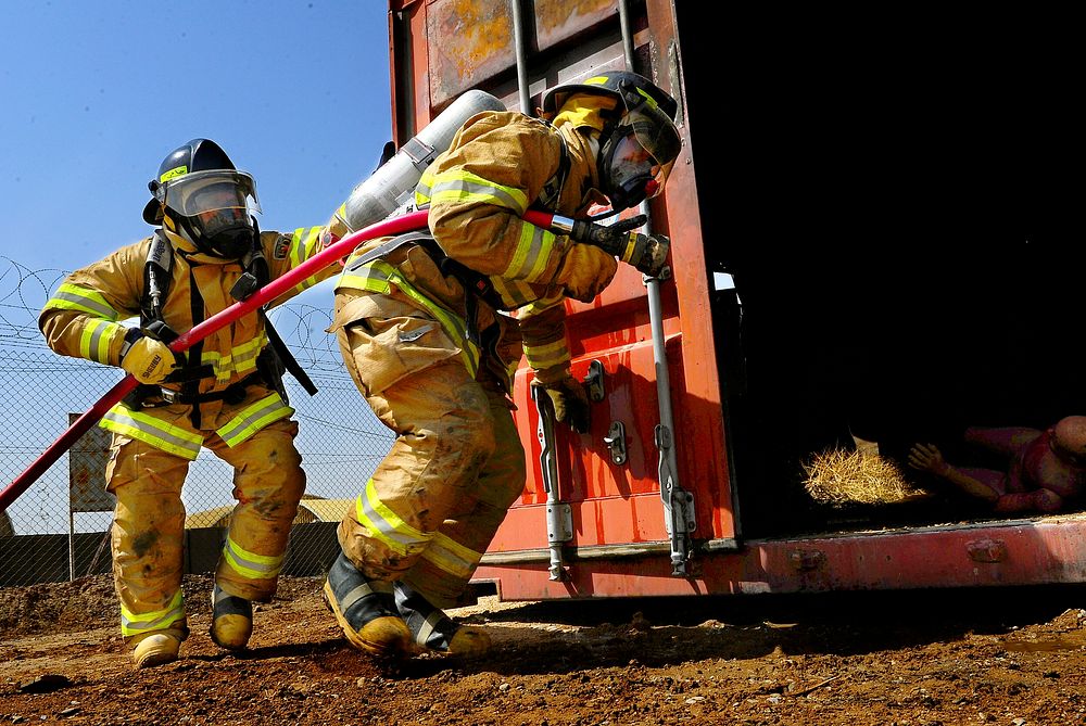 Members of the Afghan National Air Force fire department prepare to enter a storage container to practice firefighting…