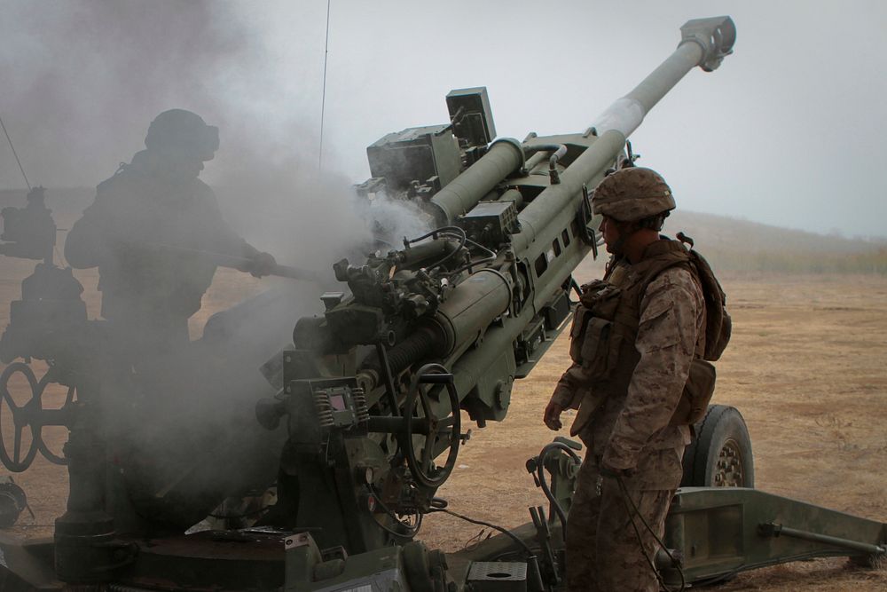 U.S. Marines with India Battery, 3rd Battalion, 11th Marine Regiment, swab the breech of an M777 Lightweight Howitzer after…