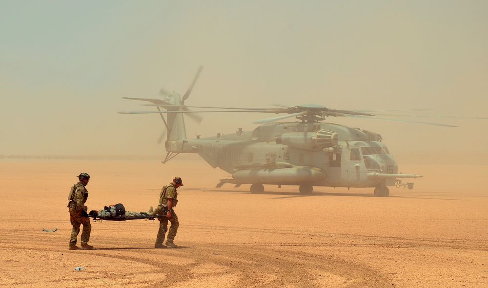 Two U.S. Air Force pararescuemen assigned to the 82nd Expeditionary Rescue Squadron rush an exercise participant with…