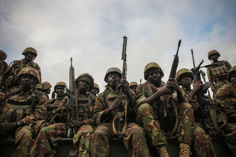 Troops from the Kenyan Contingent of the African Union Mission in Somalia (AMISOM) sit on the back of a flat-bed military…