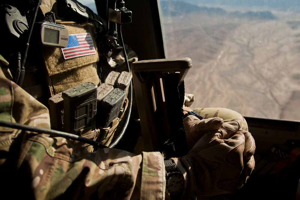 A coalition forces member looks out of a UH-60 Black Hawk helicopter during a battlefield circulation over Farah province…