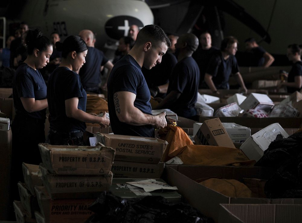 U.S. Sailors sort through mail in the hangar bay aboard the aircraft carrier USS Nimitz (CVN 68) in the Arabian Sea July 20…