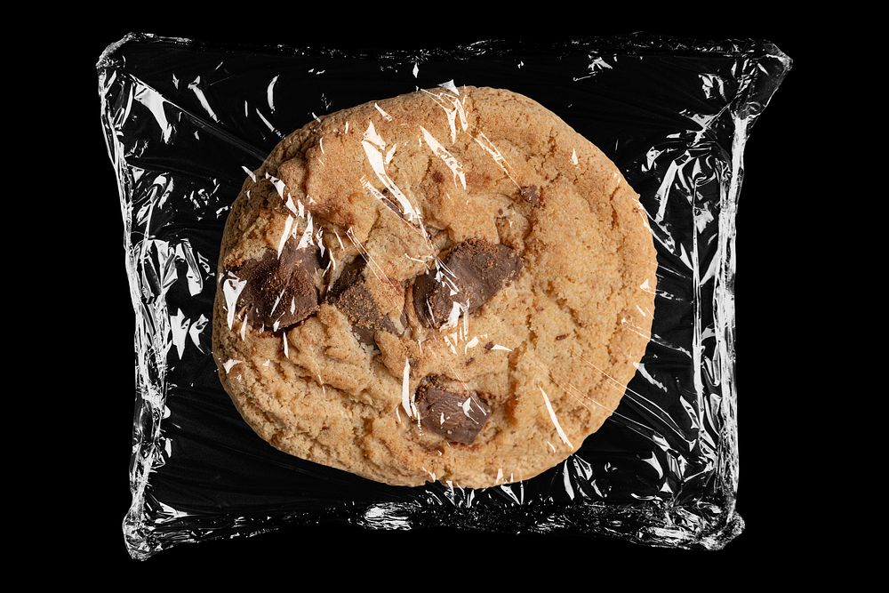 Chocolate chip cookie in plastic, black background