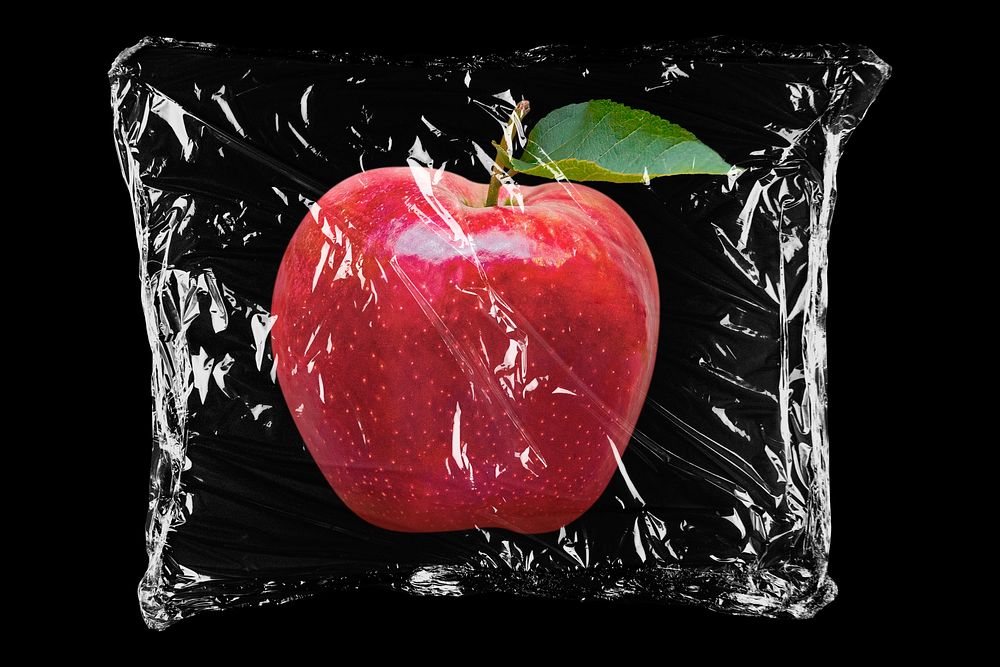 Apple in plastic, black background