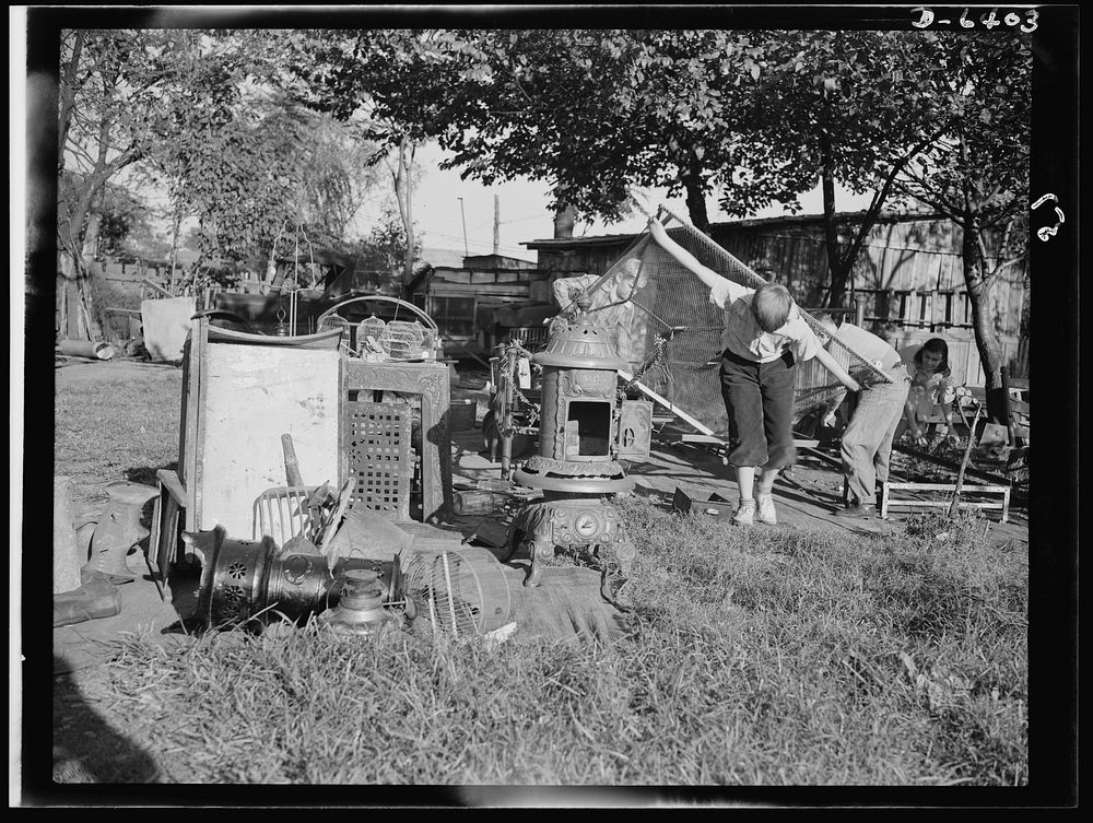 Manpower, junior size. A couple of husky junior commandos add to a neighborhood scrap pile in Roanoke, Virginia. Bedsprings…