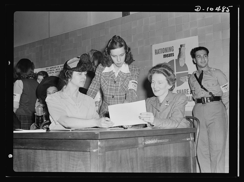 Sugar rationing. Sign here please. Mrs. Bennett Champ Clark, wife of the Senator from Missouri, gets a preview of sugar…