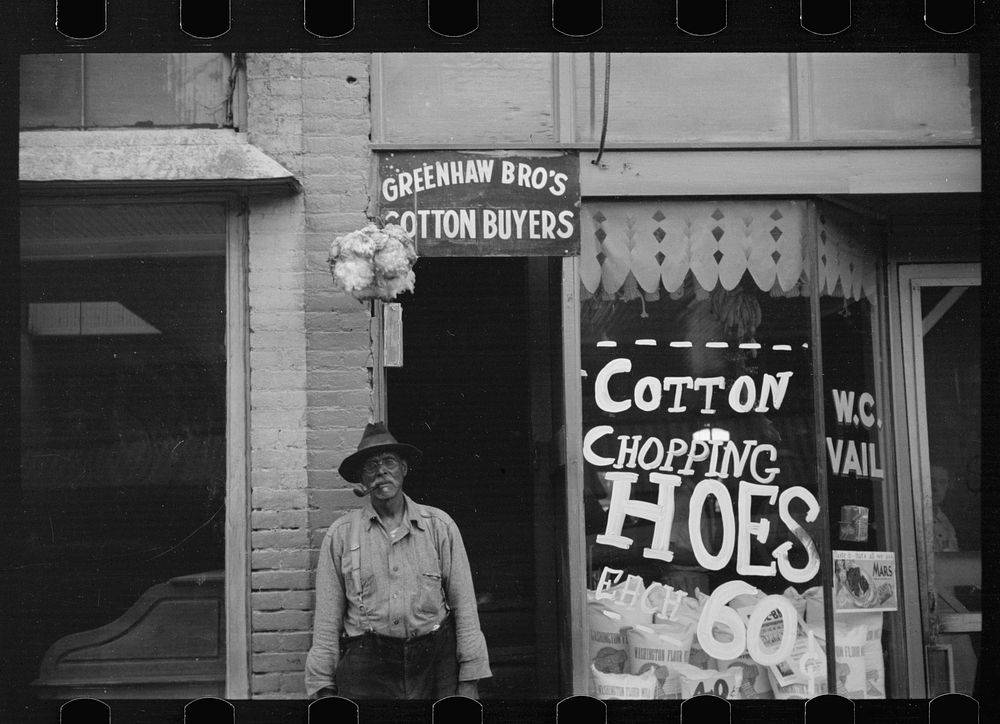 Typical view of store and cotton trader in small Arkansas town. This one made in Marianna, Arkansas. Sourced from the…