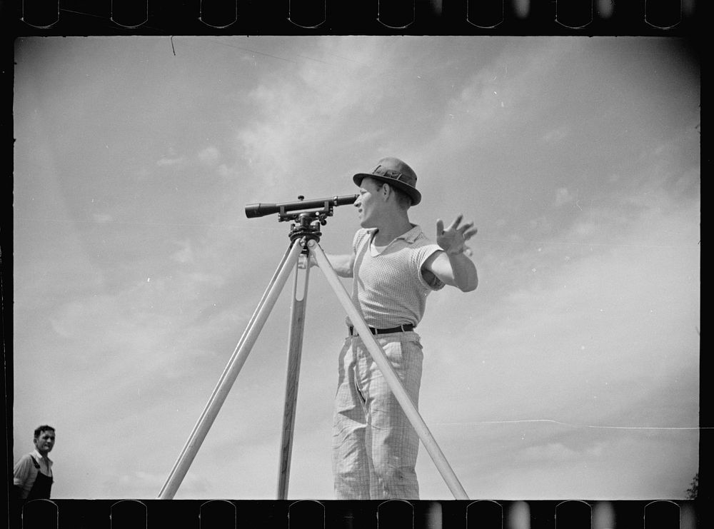 Surveyor working in a model community planned by the Suburban Division of the United States Resettlement Administration…
