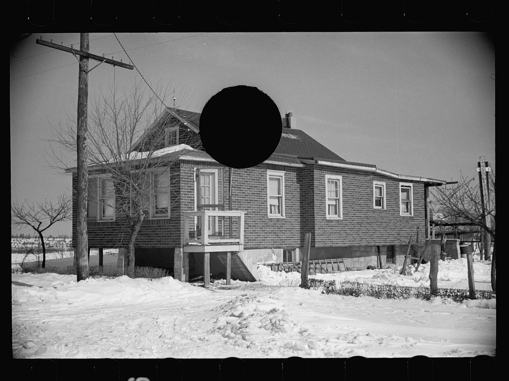 [Untitled photo, possibly related to: Cheap false brick tarpaper-covered wooden house typical of subdivision sections in…
