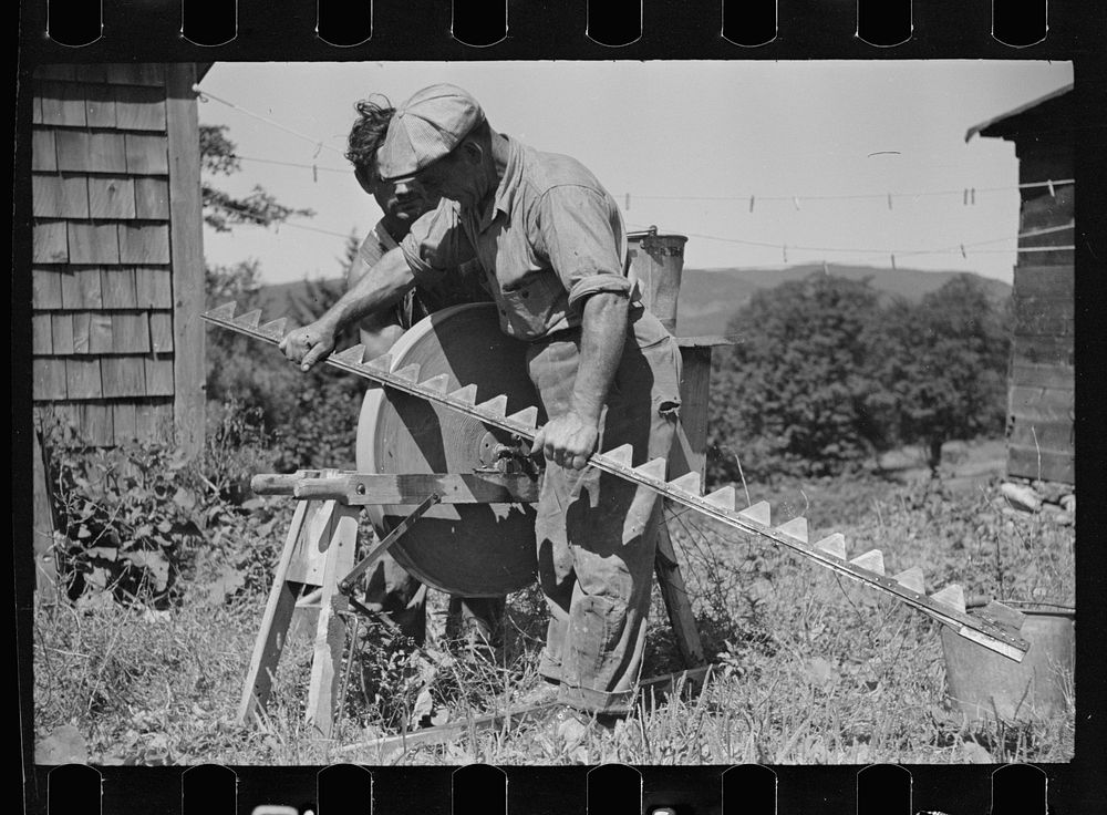 Sharpening knife of old mowing machine on farm near Hyde Park, Vermont. Sourced from the Library of Congress.