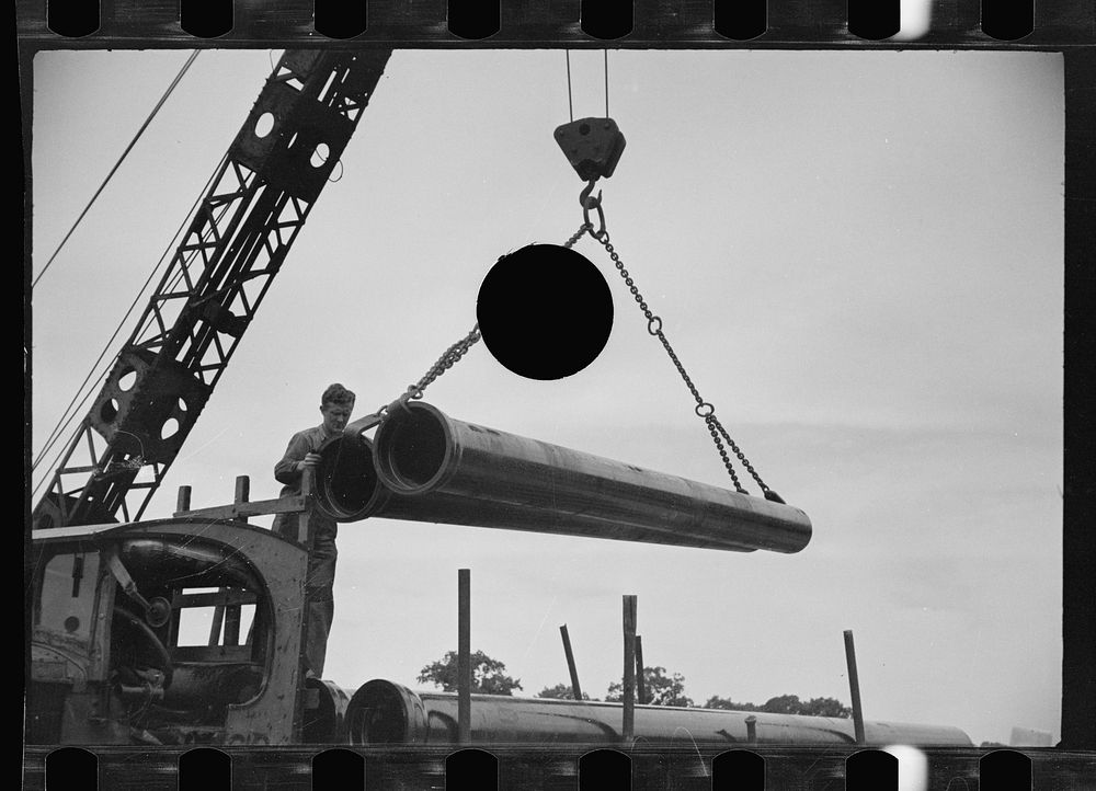 [Untitled photo, possibly related to: Unloading pipe with crane, Greenbelt, Maryland]. Sourced from the Library of Congress.