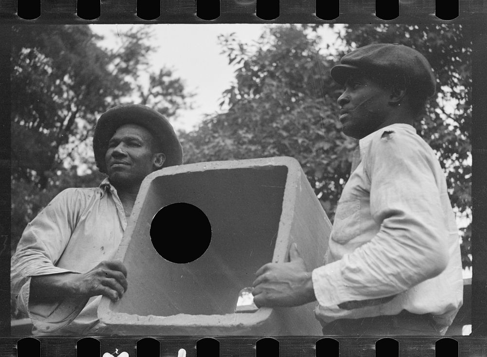 [Untitled photo, possibly related to: Workmen unloading tile pipe, Greenbelt, Maryland]. Sourced from the Library of…