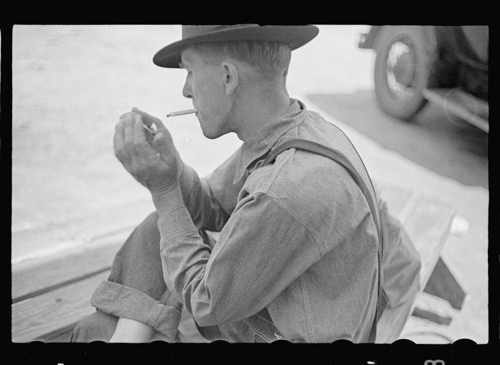[Untitled photo, possibly related to: Rolling a cigarette. Irwinville Farms, Georgia]. Sourced from the Library of Congress.