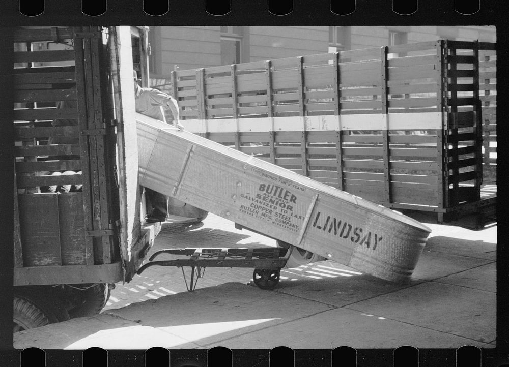 [Untitled photo, possibly related to: Loading tank onto truck at farm machinery warehouse, Minneapolis, Minnesota]. Sourced…
