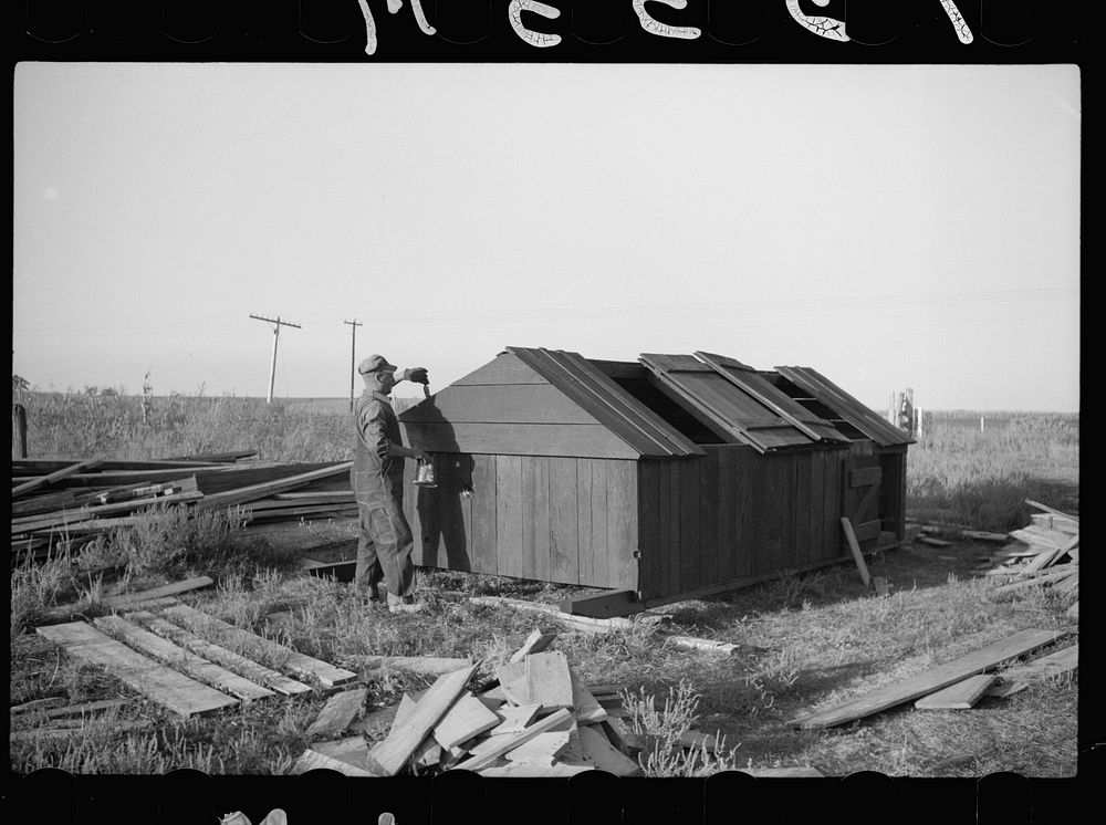 Rehabilitation client painting hog house which he built himself, Grant County, Wisconsin. Sourced from the Library of…