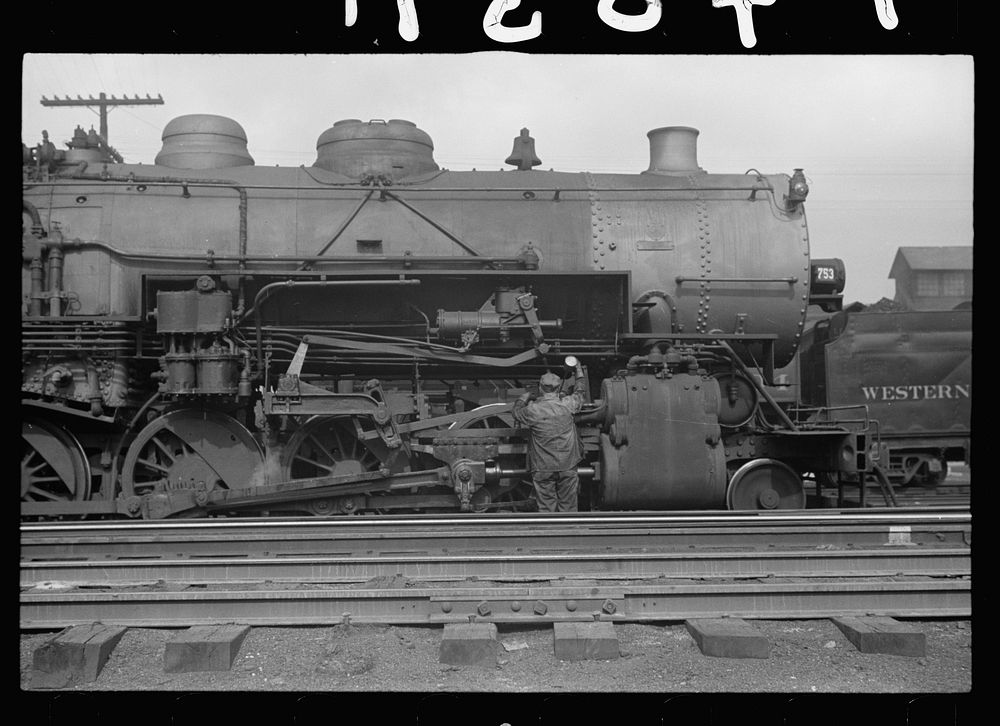 Yard brakeman oiling locomotive, Elkins, West Virginia. Sourced from the Library of Congress.
