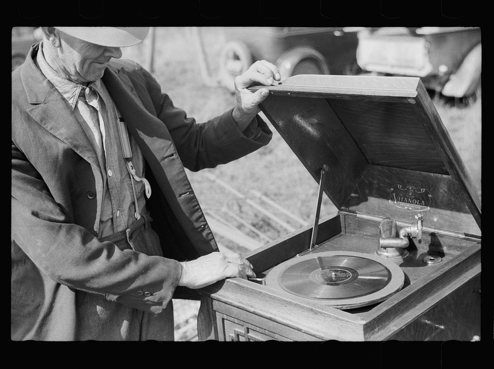 Farmer examining phonograph. Auction near Tenstrike, Minnesota. Sourced from the Library of Congress.