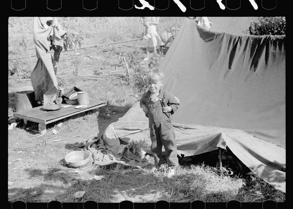 [Untitled photo, possibly related to: Migrant child eating in front of tent home, Berrien County, Michigan]. Sourced from…