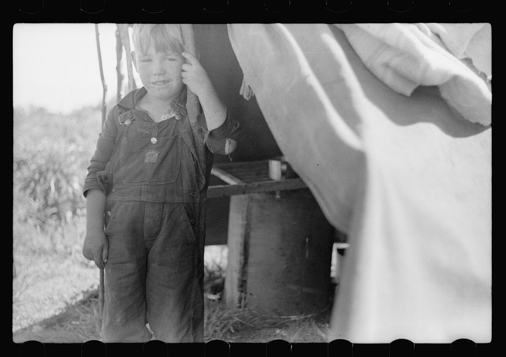 [Untitled photo, possibly related to: Migrant child eating in front of tent home, Berrien County, Michigan]. Sourced from…