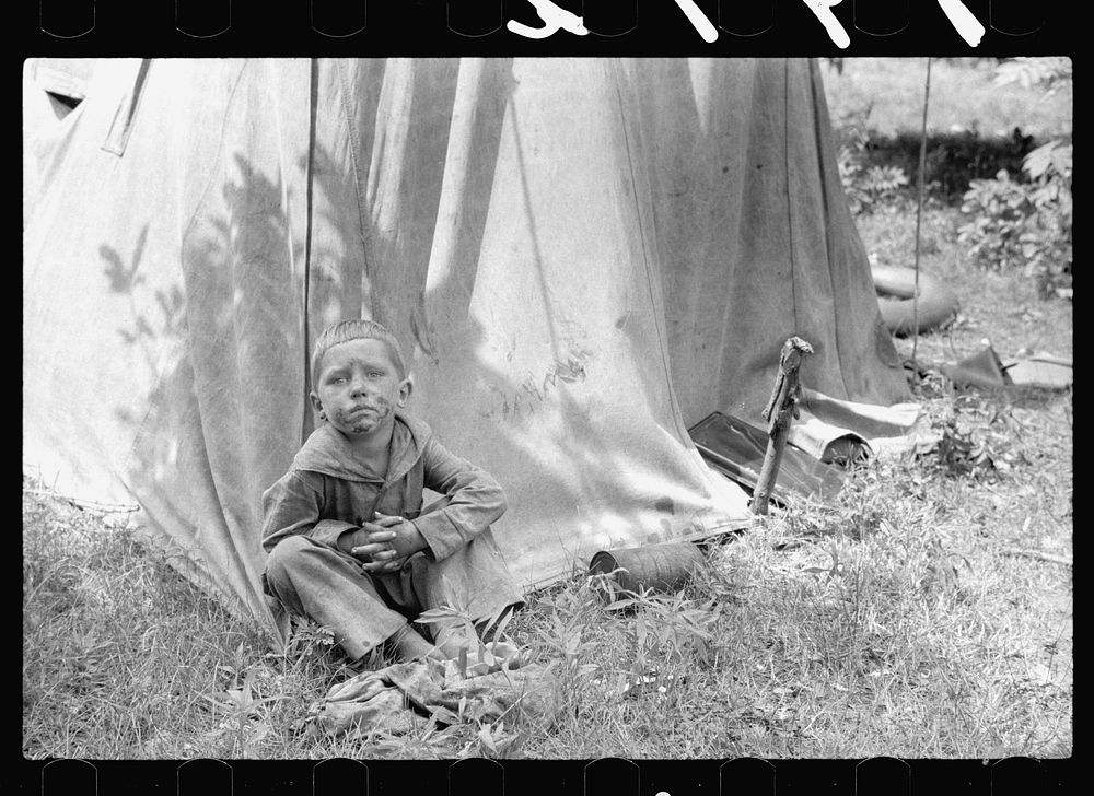 Migrant child in front of tent home, Berrien County, Mich.. Sourced from the Library of Congress.