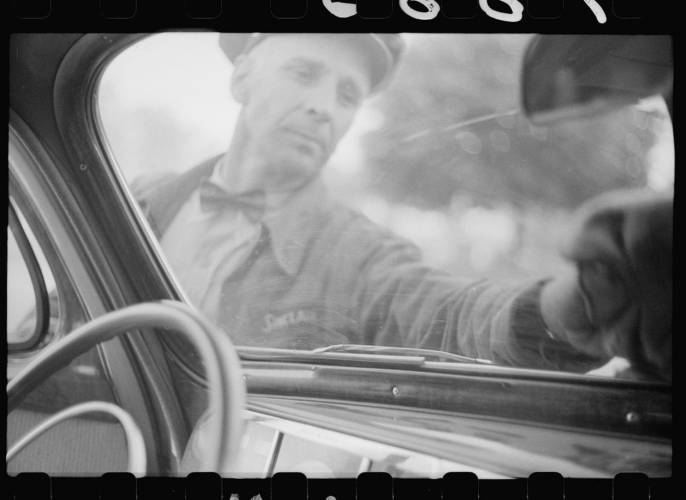 Wiping off windshield in service station, Cairo, Illinois. Sourced from the Library of Congress.