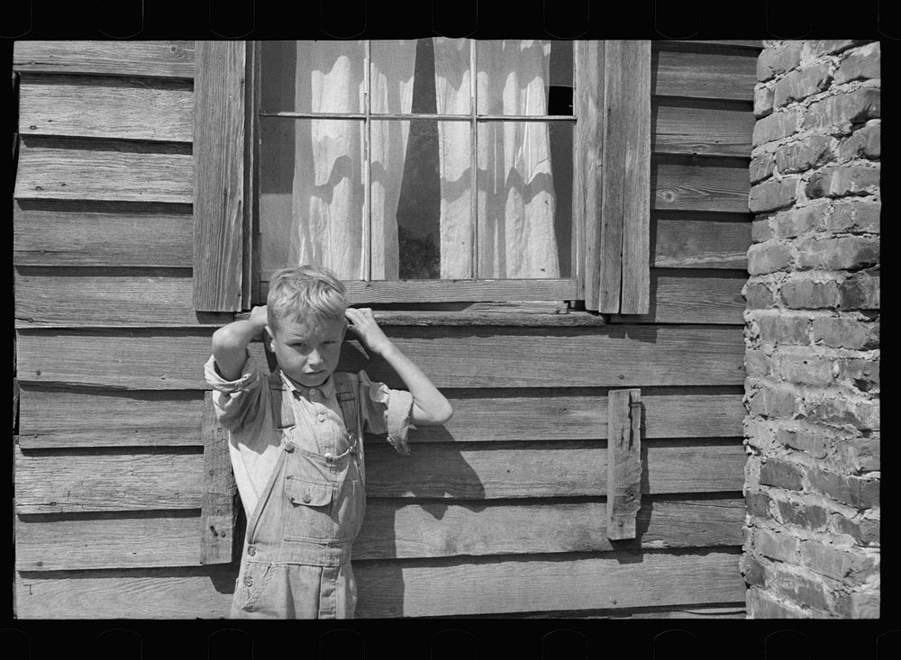 [Untitled photo, possibly related to: Son of a farmer on Wolf Creek Farms project who has not yet been moved to a new house…