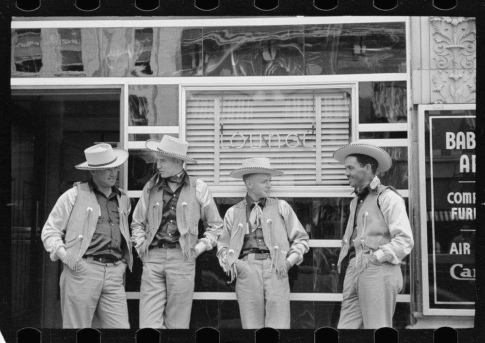 Dudes in town, Billings, Montana. Four cowboys dress alike in front of bar. Sourced from the Library of Congress.