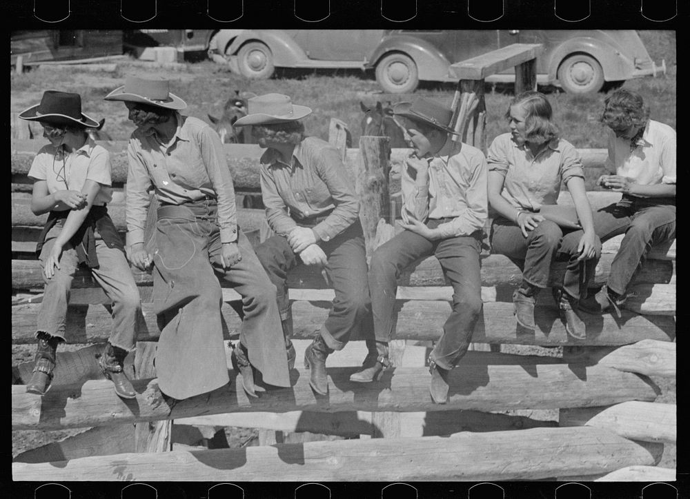 Dude girls on a corral fence, Quarter Circle U roundup, Montana. Sourced from the Library of Congress.