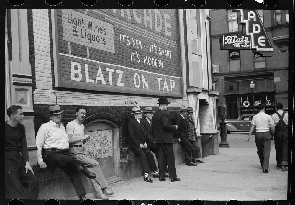 Men lounging in front of the arcade, Butte, Montana. Sourced from the Library of Congress.