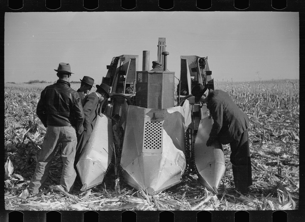 Farmers examine a two-row mounted corn picker, mechanical cornhusking contest, Hardin County, Iowa. Sourced from the Library…