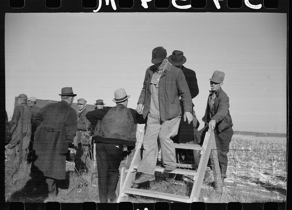 Farmers coming over a stile, at mechanical cornhusking contest, Hardin County, Iowa. Sourced from the Library of Congress.