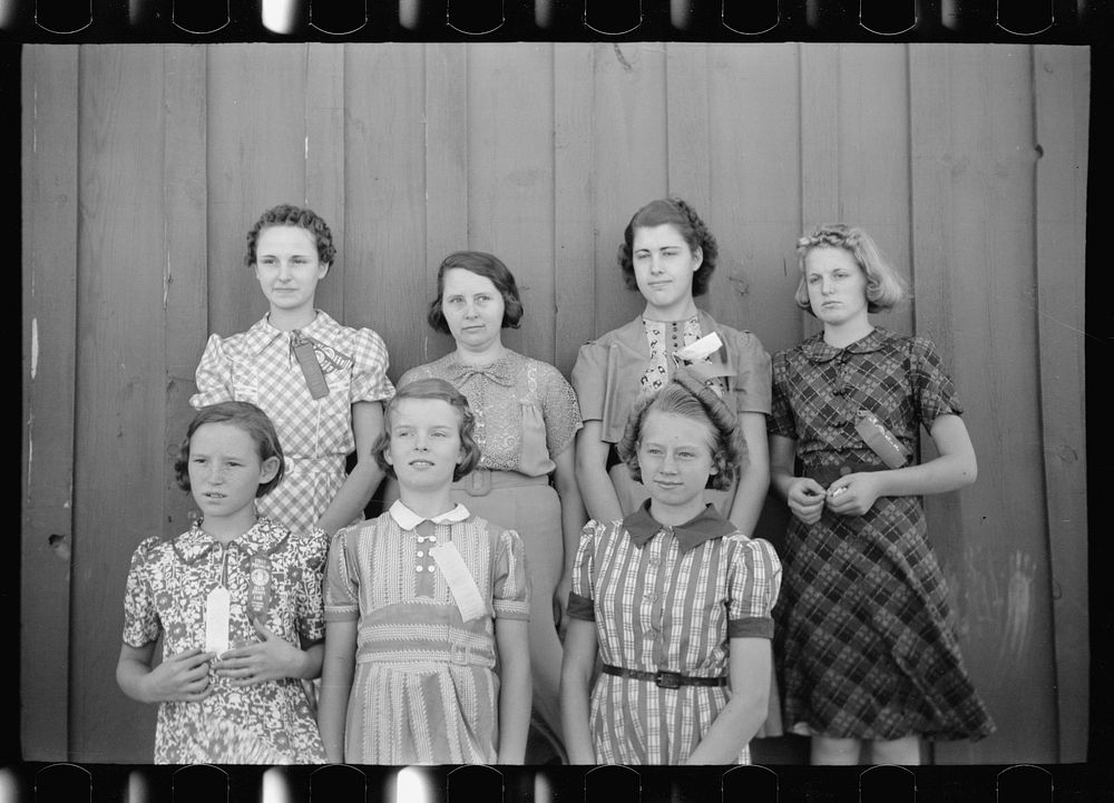 Daughters of resettlement clients who have formed 4-H Club and won fair prizes posed with their leader, Mrs. Lucky (second…